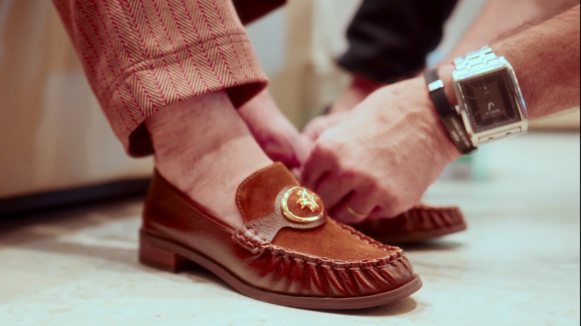 Pixolé 50 anos — detalhe, calçando um mocassim